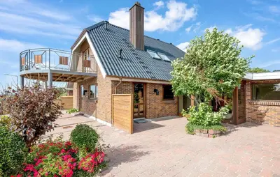 a brick house with a metal roof and a balcony at Pet Friendly Home In Lemvig With Wifi in Lemvig