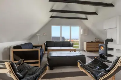 a living room with a couch and chairs and a fireplace at Pool house with beautiful view by the sea - SJ650 in Lemvig