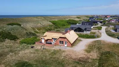 an aerial view of a house on the beach at Thatched house with spa and pool by the sea - SJ67 in Harboør