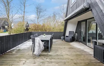 a wooden deck with a table and chairs on a house at Awesome Home In Farsø With Wifi in Farsø