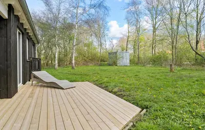 a bench sitting on a deck next to a yard at 4 Bedroom Nice Home In Vinderup in Vinderup