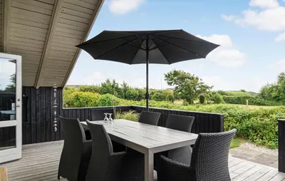 a table and chairs with an umbrella on a deck at Cozy Home In Vestervig With Wifi in Vestervig