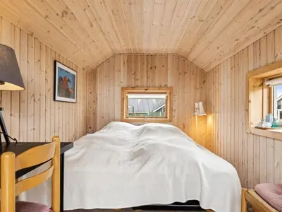 a bed in a room with a wooden ceiling at Holiday Home Dolores - 200m from the sea by Interhome in Torsted