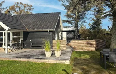 a house with a wooden deck with two potted plants at 3 Bedroom Amazing Home In Vestervig in Vestervig