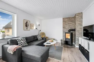 a living room with a couch and a fireplace at Nyd den skønne natur ved hav og fjord in Thyborøn