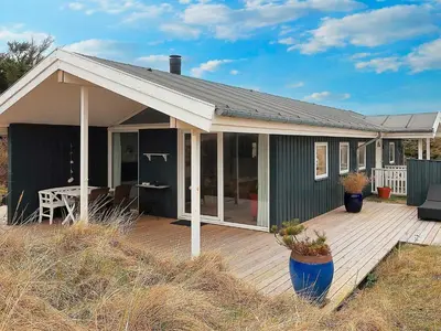 a house with a deck with a table on it at 4 star holiday home in Blokhus-By Traum in Blokhus