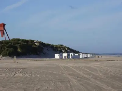 a row of white buildings on a beach at 4 star holiday home in Blokhus-By Traum in Blokhus