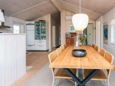 a dining room with a wooden table and chairs at 4 star holiday home in Blokhus-By Traum in Blokhus