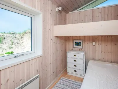a small bedroom with a bunk bed and a window at 4 star holiday home in Blokhus-By Traum in Blokhus
