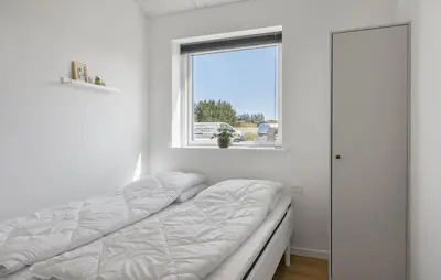 a bed in a white room with a window at Gorgeous Home In Saltum With Sauna in Saltum