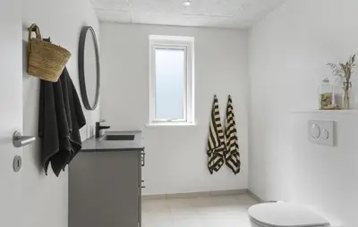 a white bathroom with a toilet and a sink at Gorgeous Home In Saltum With Sauna in Saltum