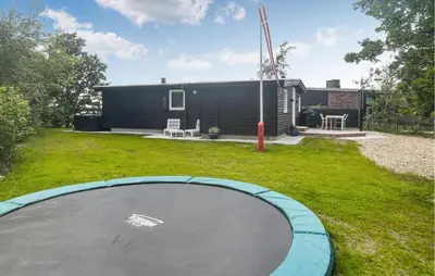 a trampoline in the yard of a house at 2 Bedroom Awesome Home In Højslev in Højslev