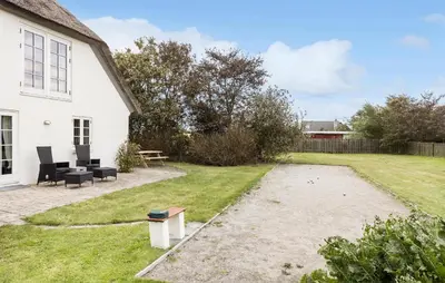 a backyard of a white house with a patio at 4 Bedroom Cozy Home In Vestervig in Vestervig