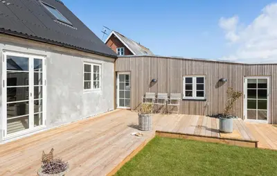 a backyard with a wooden deck and a house at Lovely Home In Thisted With Wifi in Thisted