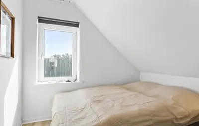 a bed in a white room with a window at Lovely Home In Thisted With Sauna in Thisted