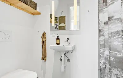 a white bathroom with a sink and a mirror at Lovely Home In Thisted With Sauna in Thisted