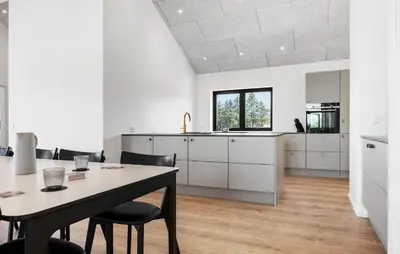a large white kitchen with a table and chairs at Stunning Home In Saltum With Sauna in Saltum