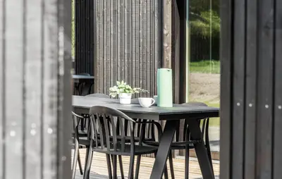 a table with chairs and a candle on a patio at Stunning Home In Saltum With Sauna in Saltum