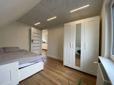 a bedroom with a bed and white cabinets at Sunny apartment in Åbybro