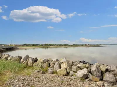 a large group of rocks next to a body of water at 5 star holiday home in Vinderup-By Traum in Vinderup