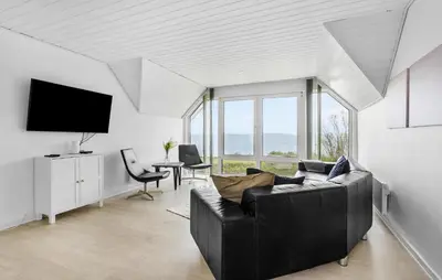 a living room with a black couch and a tv at 3 Bedroom Beautiful Home In Vesløs in Vesløs
