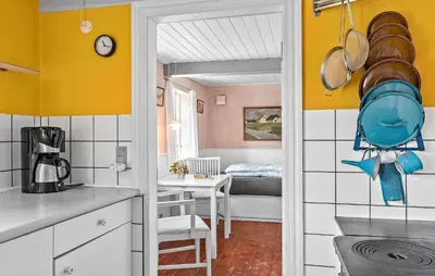 a kitchen with yellow walls and a room with a table at 4 Bedroom Nice Home In Blokhus in Blokhus