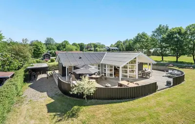 a large house with a deck and a backyard at Pet Friendly Home In Farsø With Wifi in Farsø
