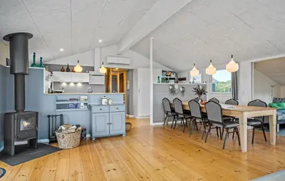 a kitchen and dining room with a table and a fireplace at Nice Home In Lemvig With Wifi in Lemvig