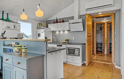 a kitchen with white appliances and a wooden floor at Nice Home In Lemvig With Wifi in Lemvig