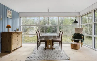 a dining room with a table and chairs and windows at 2 Bedroom Nice Home In Fjerritslev in Fjerritslev