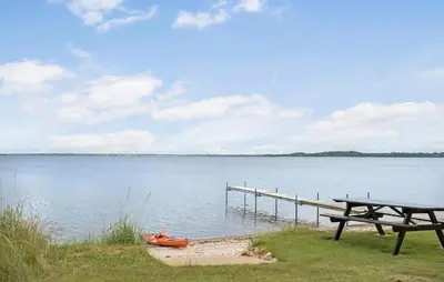 a picnic table and a dock on a lake at Amazing Home In Højslev With Wifi in Højslev