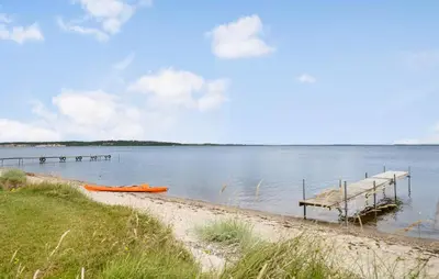 a dock on a lake with a boat in the water at Amazing Home In Højslev With Wifi in Højslev