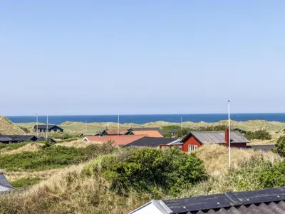 a group of houses on a hill with the ocean in the background at Holiday Home Letje - 500m from the sea by Interhome in Løkken