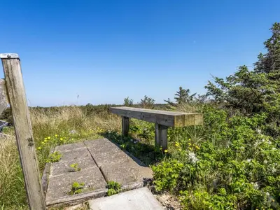 a bench sitting on the side of a hill at Holiday Home Letje - 500m from the sea by Interhome in Løkken