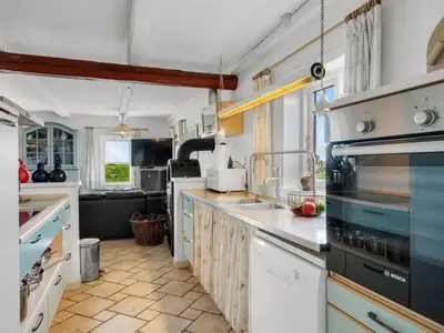 a kitchen with white cabinets and a counter top at Holiday Home Edvardsine - 20m to the fjord by Interhome in Vestervig
