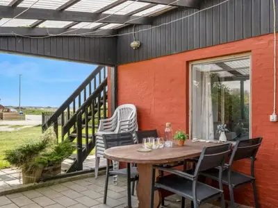 an outdoor patio with a wooden table and chairs at Holiday Home Edvardsine - 20m to the fjord by Interhome in Vestervig
