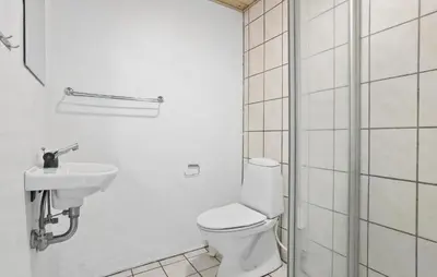 a white bathroom with a toilet and a sink at Cozy Home In Spøttrup With Sauna in Spottrup