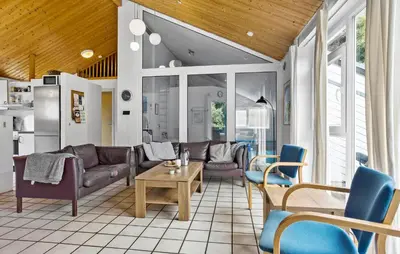 a living room with couches and a table and chairs at Cozy Home In Spøttrup With Sauna in Spottrup