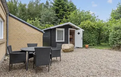 a table and chairs in front of a tiny house at Cozy Home In Spøttrup With Sauna in Spottrup