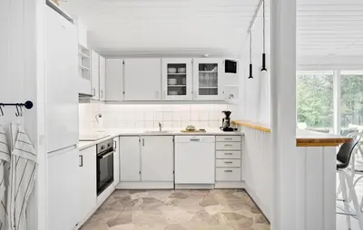 a white kitchen with white cabinets and a window at 4 Bedroom Beautiful Home In Blokhus in Blokhus