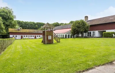 a grassy yard with a playground in front of a building at Lejl 4 in Brovst