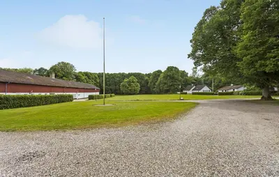 a gravel road next to a building and a pole at Lejl 4 in Brovst