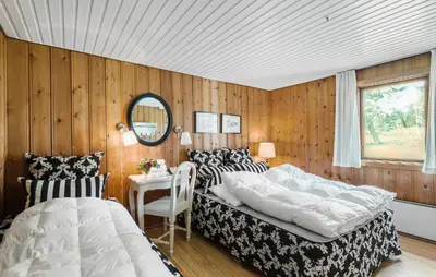 a bedroom with two beds and a mirror at Røgegård Hjortehytten in Fjerritslev