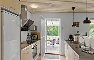 a kitchen with white cabinets and a door leading to a patio at Pet Friendly Home In Farsø With Kitchen in Farsø