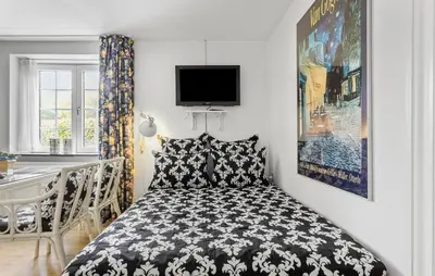 a small bedroom with a bed and a table at Lejl 3 in Brovst