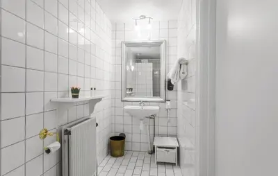 a white bathroom with a sink and a mirror at Lejl 3 in Brovst