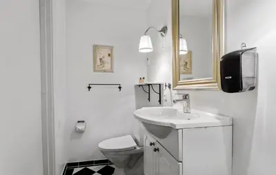 a white bathroom with a toilet and a sink at Lejl 5 in Brovst
