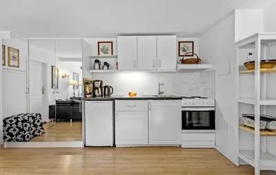 a white kitchen with white cabinets and a table at Lejl 5 in Brovst