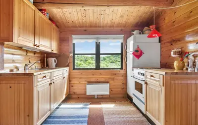 a kitchen with wooden cabinets and a refrigerator at 2 Bedroom Lovely Home In Saltum in Saltum