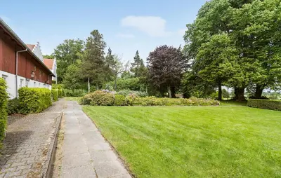 a grassy yard next to a house with a sidewalk at Lejl 7 in Brovst